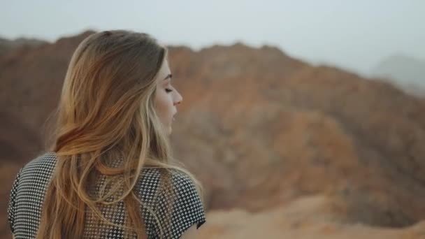 Mujer rubia joven en vestido largo camina en la cima de la montaña. Paisaje de montaña con puesta de sol, cámara lenta, full hd — Vídeos de Stock