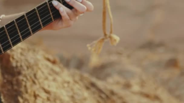 Woman playing guitar and singing in desert landscapes, desert mountains background, slow motion, full hd — Stock Video