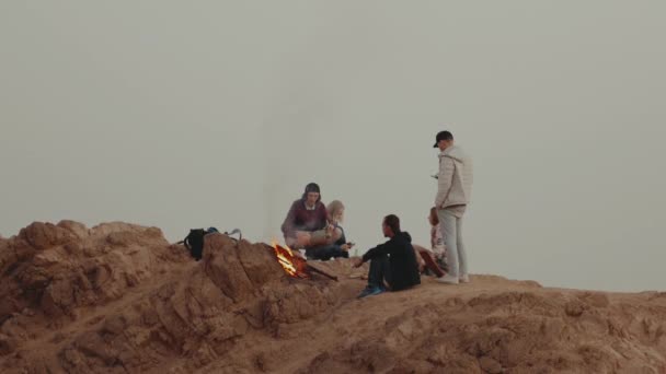 Grupo de pessoas relaxando no topo de uma montanha no pôr do sol, sentado perto de fogueira, desfrutando de seu tempo amizade, juventude, câmera lenta, hd completo — Vídeo de Stock