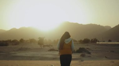 Kadınlar sahilde yürürler ve Horizon 'a bakarlar. Kumsal manzarası ve mavi deniz kadın sırtından, yavaş çekim, tam HD