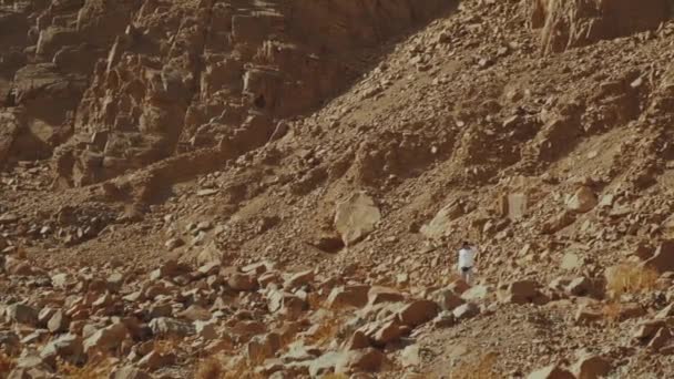 Hombre de turismo caminar a lo largo del cañón de roca en el desierto caliente. Desierto rocas fondo, Egipto, Sinaí, cámara lenta, full hd — Vídeos de Stock