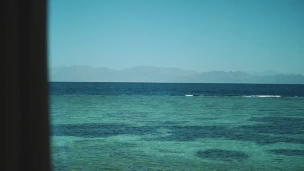 Raamzicht op de zee, golven en palmbomen, blauwe lucht, langzame beweging.Blauwe zee en blauwe lucht, horizon, Egypte, Sinaï, volle hd — Stockvideo