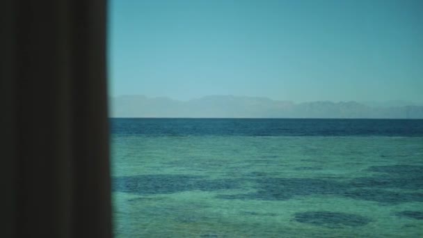 Raamzicht op de zee, golven en palmbomen, blauwe lucht, langzame beweging.Blauwe zee en blauwe lucht, horizon, Egypte, Sinaï, volle hd — Stockvideo