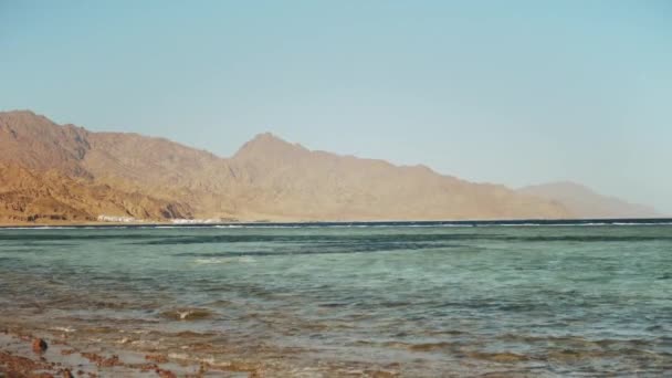 Människan snorkling i rött hav, Vackert landskap av blått hav och klar himmel, vågor i havet och bergen vid horisonten Egypten, Dahab, slow motion, full hd — Stockvideo
