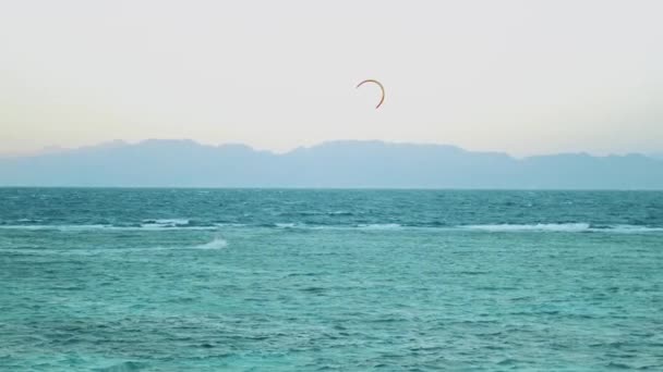 Latawce surfing w pięknej czystej wodzie w Dahab Egipt. Zwiedzanie błękitnej wody z górami w tle i ludzi windsurfing i kitesurfing, slow motion, full hd — Wideo stockowe