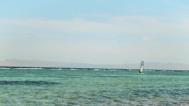 Windsurf en aguas cristalinas en Dahab Egipto. Explorando el agua azul con montañas en el fondo y la gente windsurf y kitesurf, cámara lenta, full hd — Vídeos de Stock