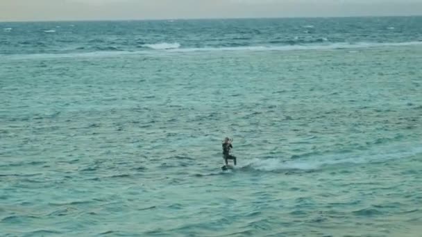 Cometa surfeando en aguas cristalinas en Dahab Egipto. Explorando el agua azul con montañas en el fondo y la gente windsurf y kitesurf, cámara lenta, full hd — Vídeo de stock