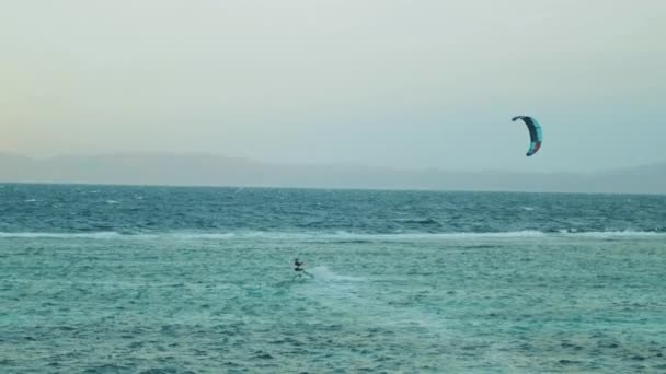 Dahab Mısır 'da temiz suda sörf yapan uçurtma. Arka planda dağlar olan mavi suyu keşfetmek ve insanlar rüzgar sörfü ve uçurtma sörfü, yavaş çekim, tam hd — Stok video