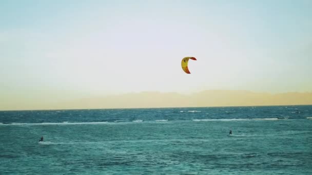 Kitesurfing i vackert klart vatten i Dahab Egypten. Utforska det blå vattnet med berg i bakgrunden och människor vindsurfing och kitesurfing, slow motion, full hd — Stockvideo
