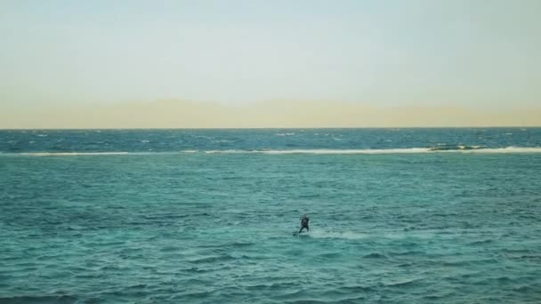 Cometa surfeando en aguas cristalinas en Dahab Egipto. Explorando el agua azul con montañas en el fondo y la gente windsurf y kitesurf, cámara lenta, full hd — Vídeo de stock