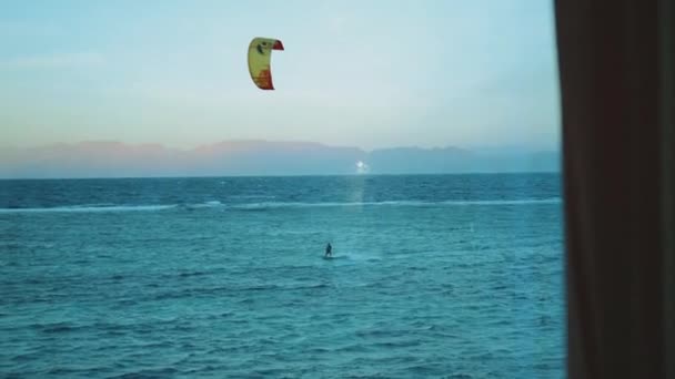 Ludzie kitesurfing w pięknej czystej wodzie w Dahab Egipt punkt widzenia z okna. Zwiedzanie błękitnego morza z górami w tle i ludzie kitesurfing, slow motion, full hd — Wideo stockowe