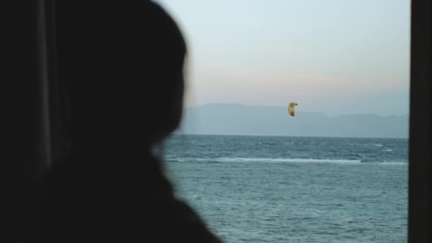 Kobieta pić wino i zobacz, jak ludzie kitesurfing w pięknej czystej wodzie w Dahab Egipt. Zwiedzanie błękitnego morza z górami w tle i ludzie kitesurfing, slow motion, full hd — Wideo stockowe