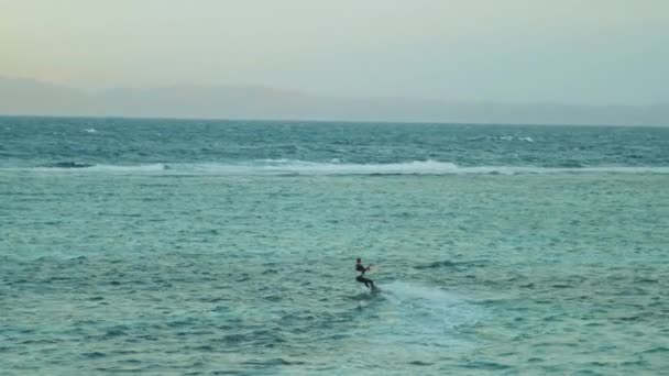 Cometa surfeando en aguas cristalinas en Dahab Egipto. Explorando el agua azul con montañas en el fondo y la gente windsurf y kitesurf, cámara lenta, full hd — Vídeos de Stock