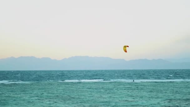 Cometa surfeando en aguas cristalinas en Dahab Egipto. Explorando el agua azul con montañas en el fondo y la gente windsurf y kitesurf, cámara lenta, full hd — Vídeos de Stock