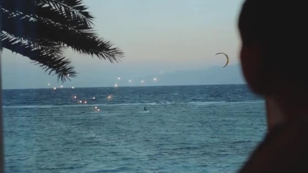 Kobieta pić wino i zobacz, jak ludzie kitesurfing w pięknej czystej wodzie w Dahab Egipt. Zwiedzanie błękitnego morza z górami w tle i ludzie kitesurfing, slow motion, full hd — Wideo stockowe