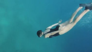 Kızıldeniz 'de mercanlarda freediver, mavi deniz suyunda yüzen güzel genç kadın, Dahab Mısır, 4k