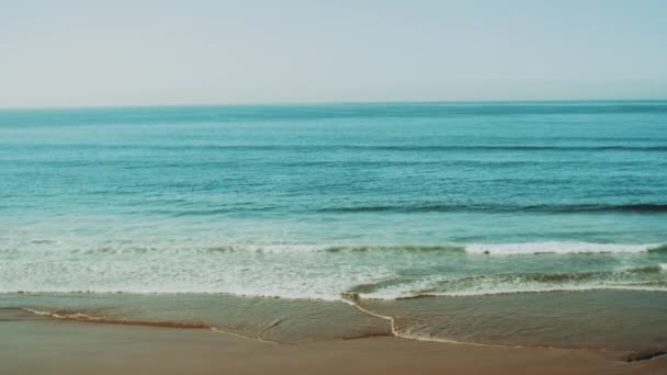 Hermosas olas del Océano Atlántico y cielo despejado, playa de arena Taghazout Marruecos, cámara lenta, 4k — Vídeos de Stock