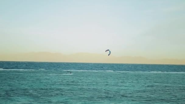 Drak surfování v krásné čisté vodě v Dahab Egypt. Prozkoumávání modré vody s horami v pozadí a lidé windsurfing a kite surfing, 4k — Stock video