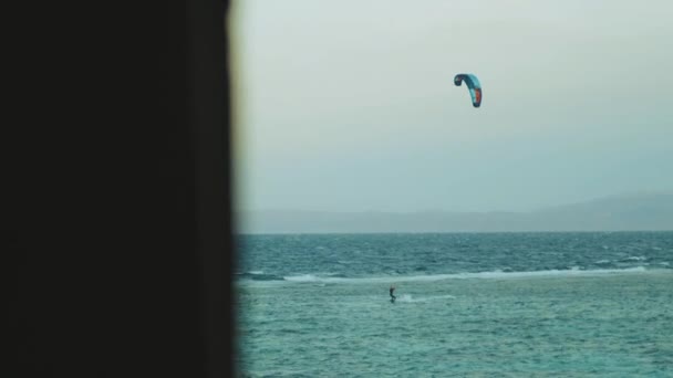 Pessoas Kite surf na bela água limpa em Dahab Egito ponto de vista da janela. Explorando o mar azul com montanhas no fundo e pessoas kite surf, 4k — Vídeo de Stock