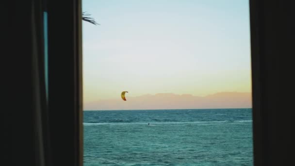 Menschen Kitesurfen in schönen klaren Wasser in Dahab Ägypten Sicht aus dem Fenster. Erkunden des blauen Meeres mit Bergen im Hintergrund und Menschen Kite-Surfen, 4k — Stockvideo