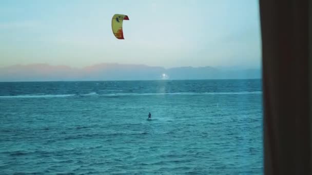 Люди кайт-серфінг у прекрасній чистій воді в Дахабському Єгипті точки зору з вікна. Дослідження синього моря з горами на задньому плані і люди, що катаються з повітрям, 4k — стокове відео
