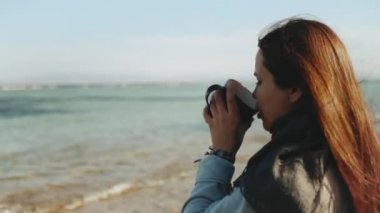 Kadın sahilde kahve ya da çay içiyor, mavi deniz manzaralı, kadın ufka bakıyor, Dahab Mısır, 4k