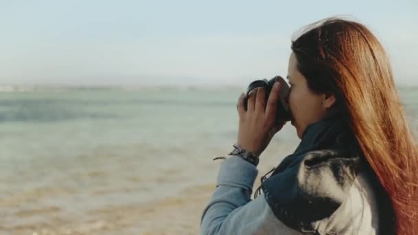 Женщина пьет кофе или чай на пляже с голубым видом на море, женщина смотреть в горизонт, Дахаб Египет, 4k — стоковое видео