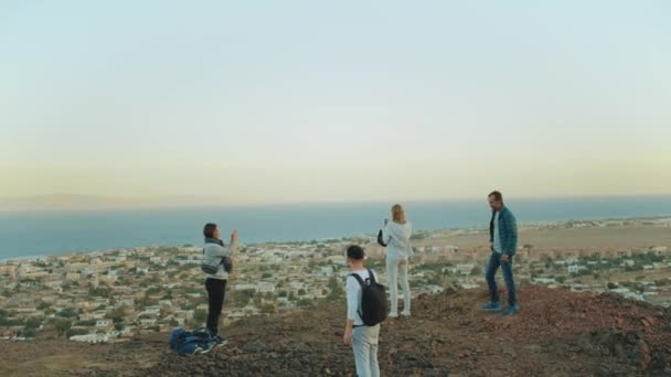Grupo de paseo turístico a lo largo del cañón de roca en el desierto caliente, los turistas toman fotos y se divierten. Montañas del desierto de fondo, Egipto, Sinaí, 4k — Vídeo de stock