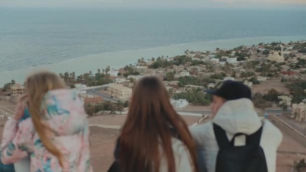 Grupo de amigos relaxando no topo de uma montanha no pôr do sol e desfrutar de vista mar Dahab Egito - amizade, juventude, 4k — Vídeo de Stock