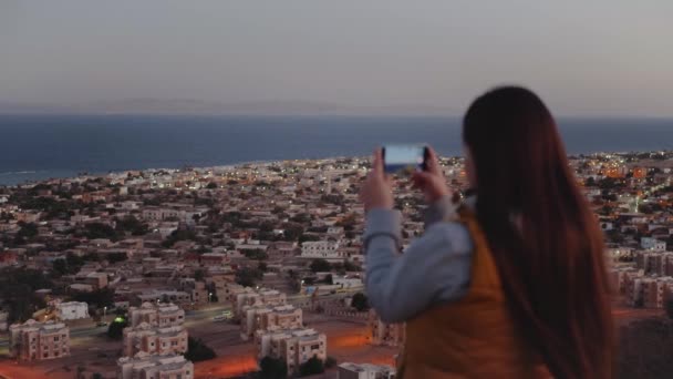 Femme prendre des photos de la mer par smartphone le soir gros plan, Femme séjour au sommet de la montagne et regardant dans Horizon, 4k — Video