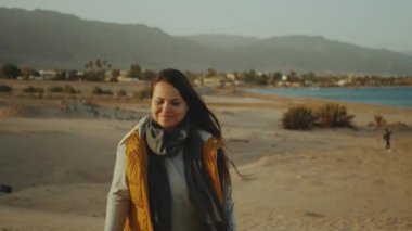 Çölde uzun saçlı bir kadın, arka planda deniz ve dağlar, Mısır, 4k.