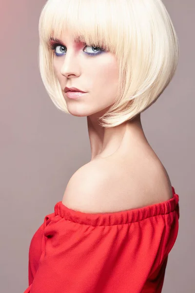 Mujer rubia con peinado bob, maquillaje, vestido rojo — Foto de Stock