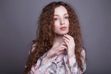 Kıvırcık saçlı güzel bir genç kadın.