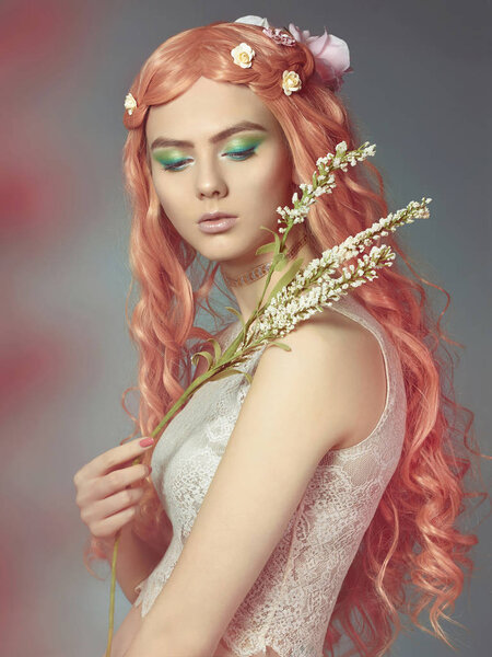Beautiful girl with long pink hair and flowers in them. Fabulous spring portrait of young woman with make up