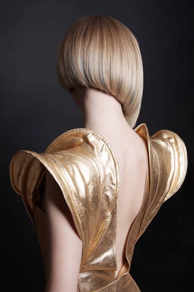 Futuristische junge Frau in sexy goldenem Kleid — Stockfoto