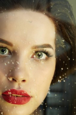 ıslak pencerenin arkasında kadın