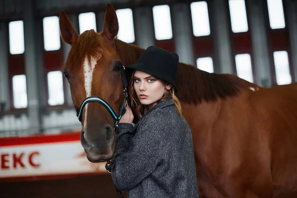 Beautiful girl in hat walking with a horse — Stock Photo, Image