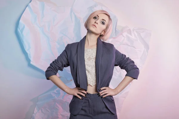 Young business woman in suit.blond bob hair model girl posing over color paper