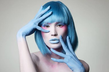 Mavi saçlı, elleri ve makyajı olan güzel bir kız.