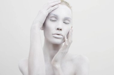 Beyaz boyalı güzel bir kadın. Vücut sanatı olan güzel çıplak kız.