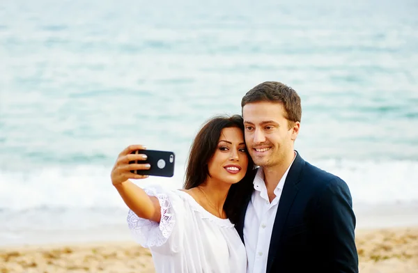 Νεαρό ζευγάρι κάνει μια selfie με το φόντο της θάλασσας. Φωτογραφία για τη μνήμη — Φωτογραφία Αρχείου