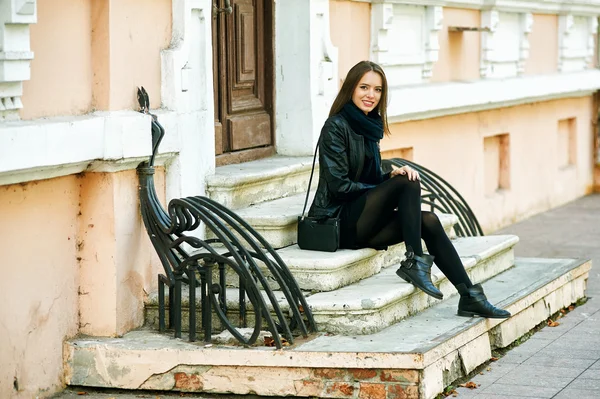 Jeune fille gaie souriant posant sur les marches de la rue de la ville — Photo