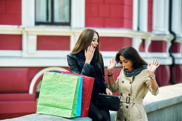 Gelukkig meisjes, kijken iets in de zak na een dagje shoppen. Verrassing van het uitgegeven bedrag — Stockfoto