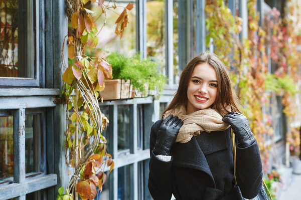 Closeup of a beautiful fashionable young woman . A walk in the autumn city