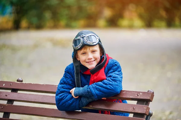 Träumt vom Fliegen. Ein Kind spielt im Park mit Retro-Luftschutzhelm und Schutzbrille . — Stockfoto