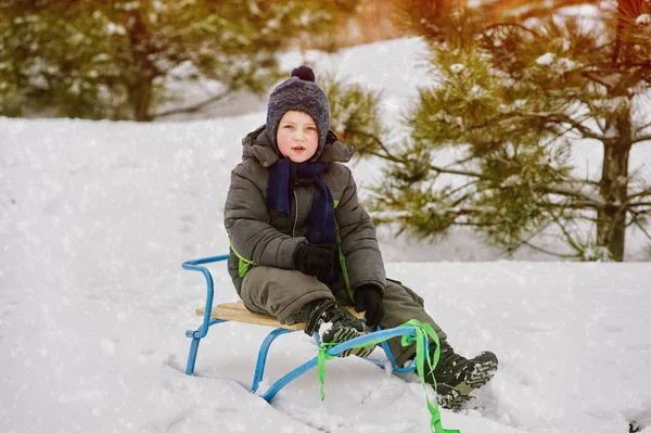 Baby beim Winterspaziergang in der Natur. ein kleines Kind auf einem Schlitten — Stockfoto