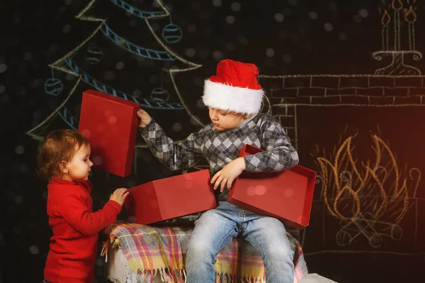 Broer en zus met rode geschenkdoos. Vrolijk kerstfeest — Stockfoto