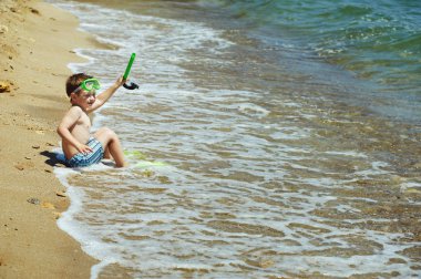 şnorkel, palet giyen sahilde poz küçük çocuk. Deniz arka plan üzerinde