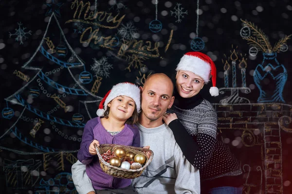 Gelukkige familie poseren over Kerstmis achtergrond. Vrolijk kerstfeest — Stockfoto