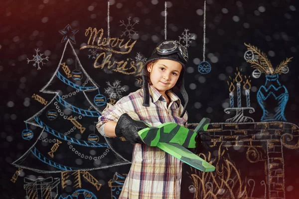 Chica jugando con un modelo de avión en un fondo de Navidad —  Fotos de Stock